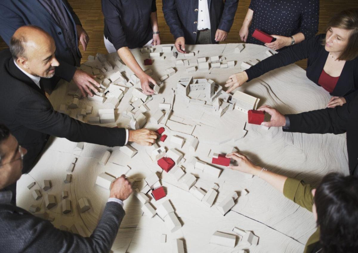 Menschen um Tisch gestalten Modell von Ort